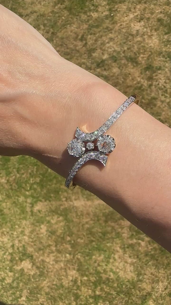 French 20th century 18ct gold and platinum Toi et Moi diamond bangle on wrist, showcasing exquisite design and craftsmanship.