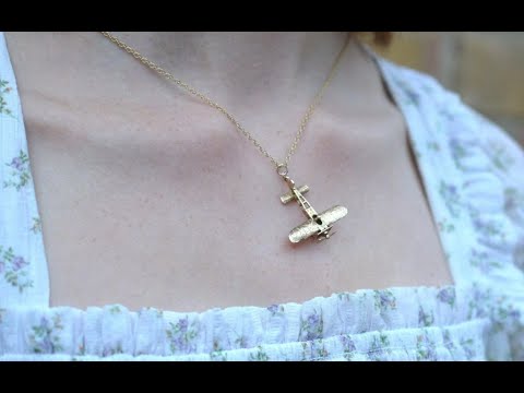 Wearing a 1970s 9ct gold vintage Aerolane pendant necklace with spinning propeller detail.